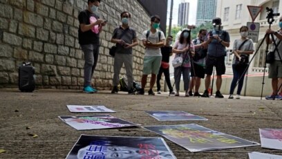 Người biểu tình thân Bắc Kinh trải ảnh của TT Trump với dòng chữ "Đáng phỉ nhổ và vô liêm sỉ" trong một cuộc biểu tình để phản đối các biện pháp trừng phạt của Mỹ bên ngoài Lãnh sự quán Mỹ tại Hong Kong hôm 8/8/2020. 