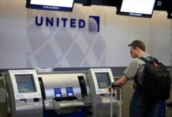 FILE - A man uses a United Airlines check-in kiosk at San Francisco International Airport in San Francisco.