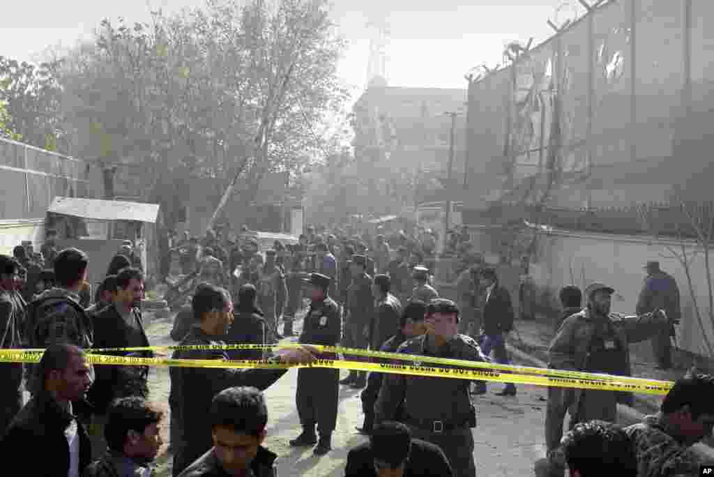 Afghan security men and media members gather at the scene of a suicide attack in Kabul, Afghanistan, November 21, 2012. 