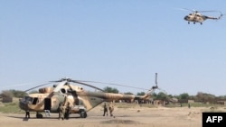 FILE - Mi-8 attack helicopters are seen in Fotokol, Cameroon, after an operation in nearby Gambaru, Nigeria. Chadian aircraft struck Boko Haram positions in the Nigerian border town for a second straight day, Feb. 1, 2015.