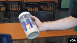 Eric Foley, CEO of Voice of the Martyrs Korea, displays a bottle filled with rice, vitamins, and a Bible, which he was prepared to send to North Korea, in Seoul, South Korea. June 5, 2020. (William Gallo/VOA)
