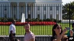 ARSIP – Foto yang diambil 22 September 2014 ini menunjukkan petugas polisi berseragam yang juga anggota Dinas Rahasia berdiri di luar Gedung Putih di Washington (foto: AP Photo/Evan Vucci, Arsip)