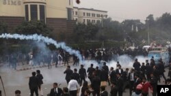 Police use tear gas shell to disperse angry lawyers back during a clash in Lahore, Pakistan, Dec. 11, 2019.