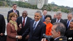 Back-dropped by the monument to revolutionary hero Ernesto "Che" Guevara, U.S. President Barack Obama greets members of his delegation after laying a wreath at the Jose Marti monument in Revolution Square in Havana, Cuba, March 21, 2016.