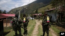 ARCHIVO - Rebeldes de las disidentes Fuerzas Armadas Revolucionarias de Colombia hacen guardia durante la liberación del rehén y soldado del ejército colombiano Juan David Estrada, en Tacueyo, suroeste de Colombia, el martes 26 de septiembre de 2023.