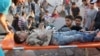 Medics remove a boy from under the rubble following what local activists said was a Russian strike in the al-Kalasa neighborhood in Syrian city of Aleppo on October 30, 2015.