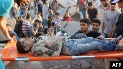 Medics remove a boy from under the rubble following what local activists said was a Russian strike in the al-Kalasa neighborhood in Syrian city of Aleppo on October 30, 2015.