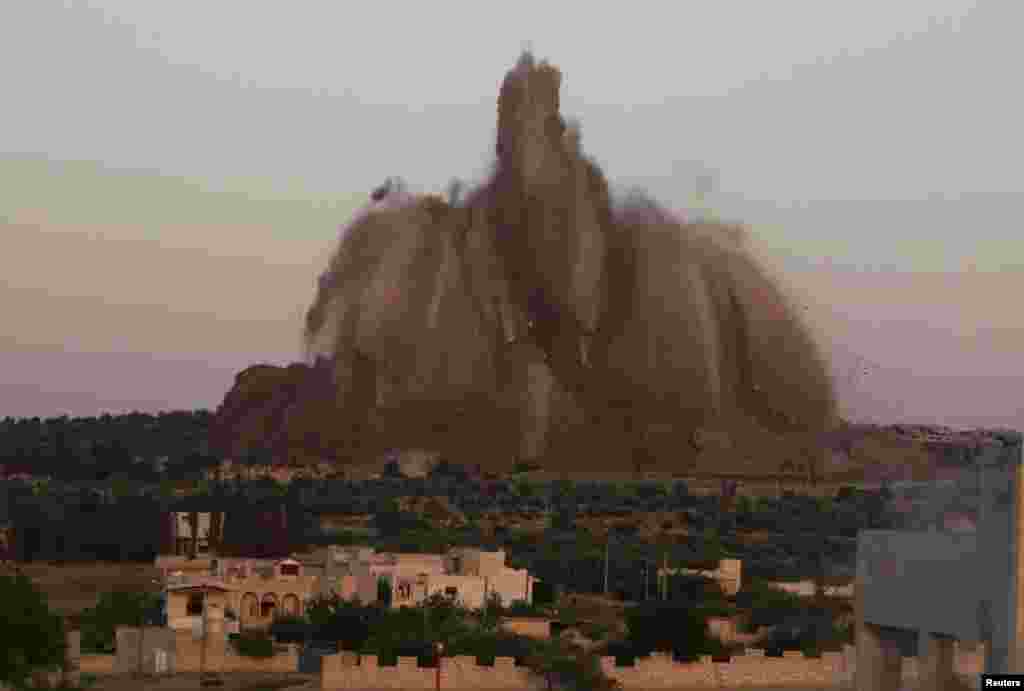 Debris rises during what rebel fighters said was an operation in which they blew up a tunnel targeting the regime&#39;s al-Sawadi checkpoint, in Idlib province, Syria, May 14, 2014.