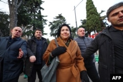 Georgian President Salome Zourabichvili, center, walks outside the parliament building as parliament members elect a new president in Tbilisi on Dec. 14, 2024.