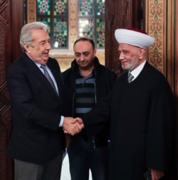 Lebanon's Grand Mufti Sheikh Abdul Latif Derian, right, shakes hand with Samir Khatib, who was once considered a favorite candidate for the post of prime minister, in Beirut, Dec. 8, 2019, in a photo released by the Lebanese government.