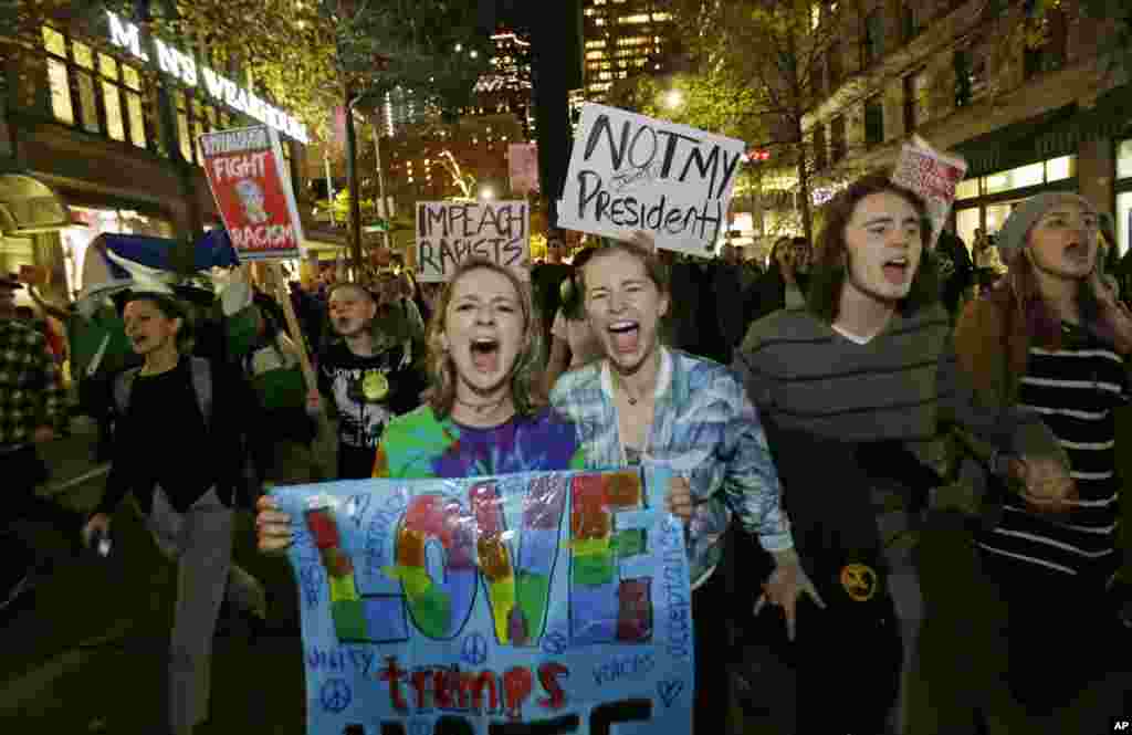 Protesters chant and hold signs during a protest against the election of President-elect Donald Trump, Nov. 9, 2016, in downtown Seattle, Washington.