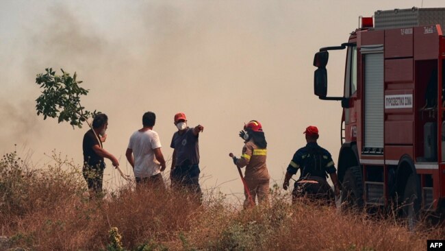 Korfu'da siviller, yangınla mücadele çalışmalarında itfaiye ekiplerine yardım ediyor.