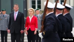 German Defense Minister Ursual von der Leyen, center, and her U.S. counterpart Ash Carter, left, inspect an honor guard during a welcome ceremony at the Defense Ministry in Berlin, Germany, June 22, 2015. 