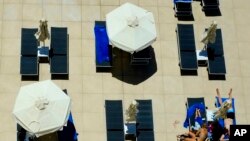 A family enjoy their vacations at the pool of Nissi Blue hotel in southeast resort of Ayia Napa, in the eastern Mediterranean island of Cyprus, Saturday, May 22, 2021. (AP Photo/Petros Karadjias)