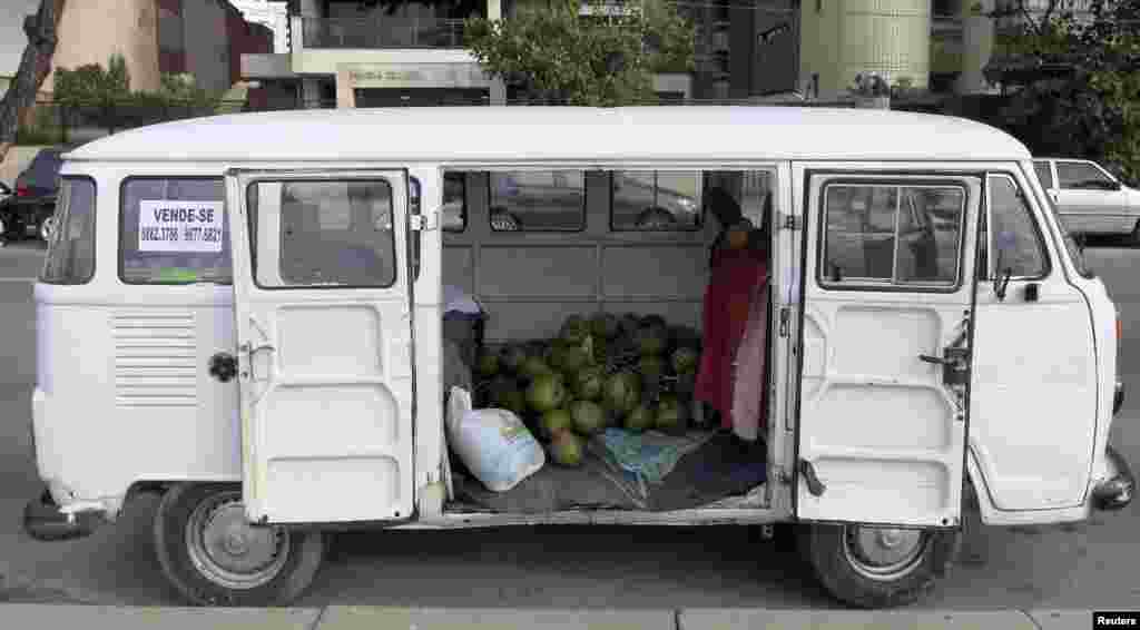 In a beachside parking area, a van contains a stockpile of coconuts, in Recife, June 11, 2014.