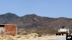 FILE - A Tunisian armored personnel carrier patrols near the Jebel Chaambi mountain, June 25, 2013.