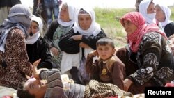 Yazidi sect members, freed eight months after they were taken captive by Islamic State militants, wait on the edge of Kirkuk for relocation, April 8, 2015.