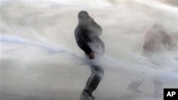 星期四在布魯塞爾歐盟總部外邊﹐比利時警方使用高壓水槍驅散示威者