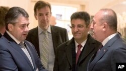 FILE - German Foreign Minister Sigmar Gabriel, left, talks to his Turkish counterpart Mevlut Cavusoglu, right, after a meeting in a hotel in Berlin, March 8, 2017. 