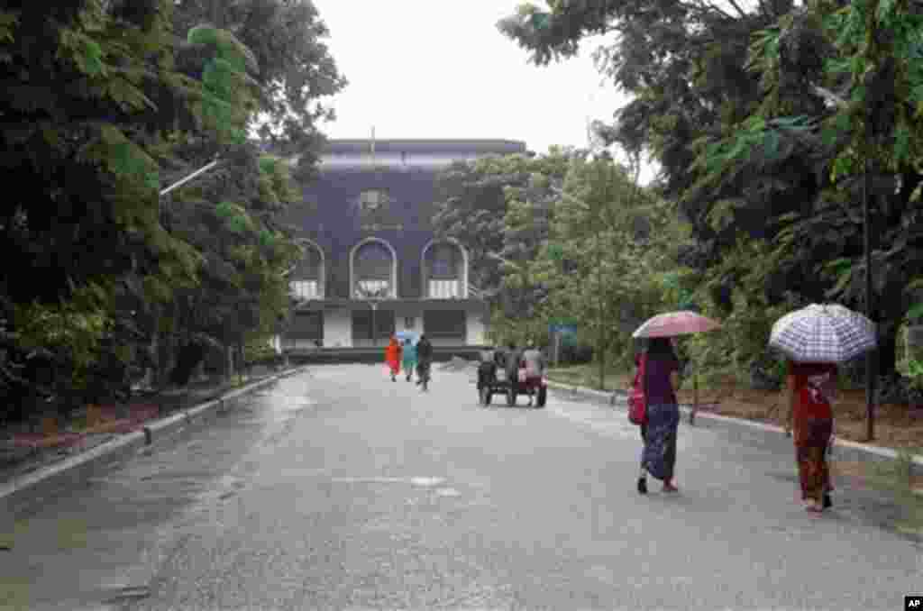 People walk on a road leading to the convocation hall of Yangon University in Yangon, Myanmar Thursday, June 28, 2012. The university was once one of Asia's finest and a poignant symbol of an education system crippled by Myanmar’s half a century of milita