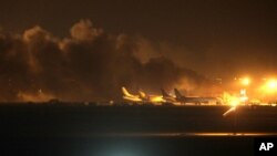 El fuego ilumina el cielo sobre el Aeropuerto Internacional Jinnah en Karachi, atacado por militantes talibanes.