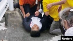 This screen grab shows former Japanese Prime Minister Shinzo Abe lies on the ground after he was shot from behind by a man during an election campaign for the July 10, 2022 Upper House election in Nara