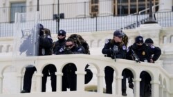 Police keep a watch on demonstrators trying to break through a police barrier, Jan. 6, 2021, at the Capitol in Washington.