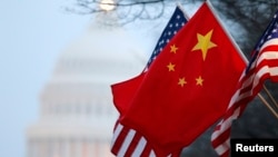 FILE - The People's Republic of China flag and the U.S. Stars and Stripes fly along Pennsylvania Avenue near the U.S. Capitol in Washington during Chinese President Hu Jintao's state visit, Jan. 18, 2011. 