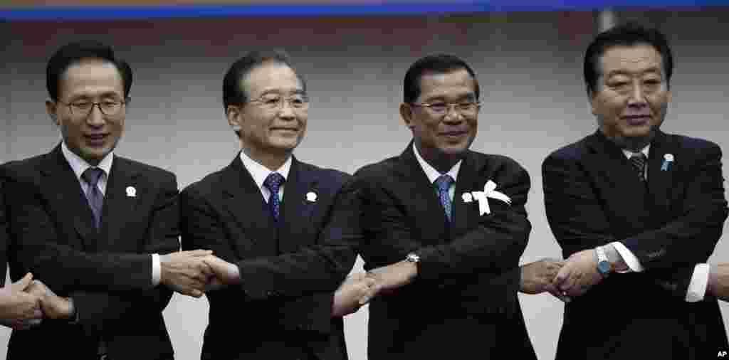 From left: South Korea's President Lee Myung-bak, China's Premier Wen Jiabao, Cambodia's Prime Minister Hun Sen and Japan's Prime Minister Yoshihiko Noda hold hands together during the ASEAN Plus Three (APT) Commemorative Summit in Phnom Penh, Cambodia, N