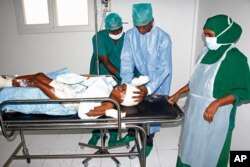 FILE - Medical workers help a child, who was injured in a mortar shell attack, at Medina hospital during Somali Independence day ceremony in Mogadishu, Somalia, July, 1, 2018.