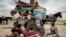FILE—A Sudanese family who fled the conflict in Murnei in Sudan's Darfur region, sit beside their belongings upon crossing the border between Sudan and Chad in Adre, Chad, July 26, 2023.