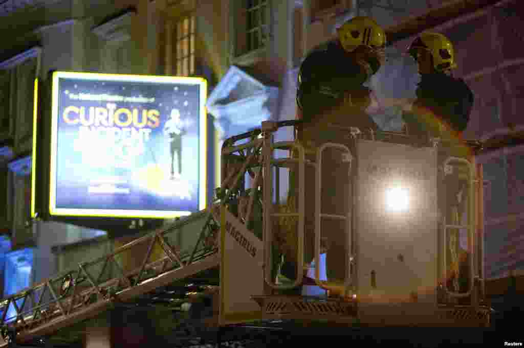 Emergency services use a cherry picker to look at the roof of the Apollo Theatre on Shaftesbury Avenue after part of the ceiling collapsed, London, Dec. 19, 2013.