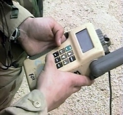 FILE - A U.S. soldier in Kuwait holds a GPS navigation device.