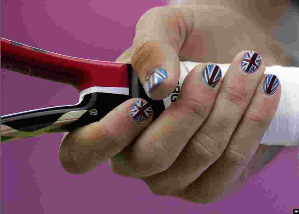 Laura Robson de Gran Bretaña muestra las uñas pintadas con la bandera británica, en el All England Lawn Tennis Club en Wimbledon,