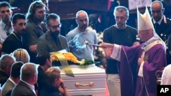 El cardenal Angelo Bagnasco bendice el ataúd del niño de nueve años, Samuel Robbiano, quien falleció en el derrumbe del puente. 
