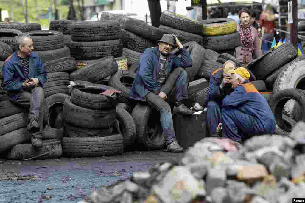 Municipal workers take a break from taking down barricades in central Kyiv, April 23, 2014. 