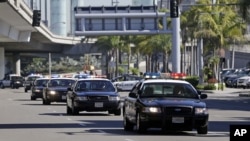 File - Police vehicles driving through Los Angeles International Airport.