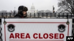 A supporter of US President-elect Donald Trump walks past a security barricade near the U.S. Capitol in Washington on Jan. 19, 2025, one day ahead of Trump's inauguration. 