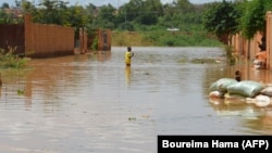 FILE: A child wades through water on a flooded street in the Kirkissoye quarter in Niamey on September 3, 2019. 