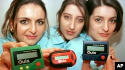 FILE - Three women hold the pager 'Quix' in Hannover, Germany, March 18, 1997. Pagers of many brands were status symbols decades before the smartphone wiped them from popular culture. But the devices remain a vital means of communication in some areas, such as healthcare.