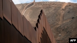 Строительная бригада занимается установкой нового участка стены на границе между США и Мексикой в Эль-Нидо-де-лас-Агилас, штат Нижняя Калифорния, Мексика, 20 января 2021 года