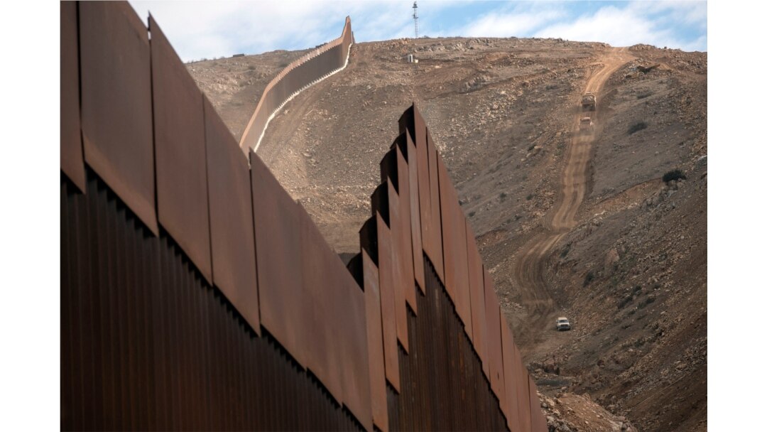 Construction crews work on a new section of the US-Mexico border fencing at El Nido de las Aguilas, eastern Tijuana, Baja California state, Mexico on Jan. 20, 2021.