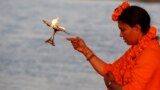 Mahant Trikaal Bhawanta, leader of the first group of women sadhvi, or Hindu holy women, performs evening rituals on the banks of River Yamuna in Allahabad, India. 