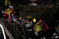 Seorang korban yang selamat dievakuasi dari lokasi runtuhnya bangunan di kota George, sekitar 400 kilometer timur Cape Town, Afrika Selatan, Selasa, 7 Mei 2024. (AP/Nardus Engelbrecht)