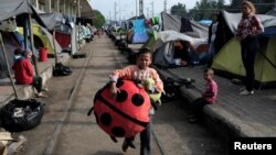 A boy walks at a railway station at a makeshift camp for refugees and migrants at the Greek-Macedonian border near the village of Idomeni, Greece, May 9, 2016.