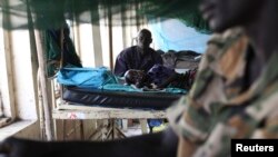 A child sick with malaria and from malnutrition lies on a bed in a hospital in Bor, South Sudan, March 15, 2014.