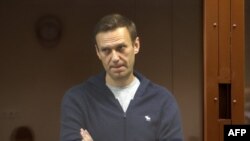 FILE - Russian opposition leader Alexey Navalny stands inside a glass cell during a court hearing in Moscow, in this handout picture provided by the Babushkinsky district court.