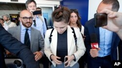 Amanda Knox, center, is approached by journalists upon her arrival in Linate airport, Milan, Italy, June 13, 2019. 