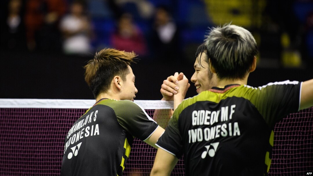 Keigo Sonoda (belakang) dan Takeshi Kamura (tak tampak di gambar) menyalami Marcus Gideon dan Kevin Sukamuljo setelah pasangan ganda putra Indonesia itu menang di final ganda putra Hong Kong Terbuka, 18 November 2018.