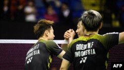 Keigo Sonoda (belakang) dan Takeshi Kamura (tak tampak di gambar) menyalami Marcus Gideon dan Kevin Sukamuljo setelah pasangan ganda putra Indonesia itu menang di final ganda putra Hong Kong Terbuka, 18 November 2018.